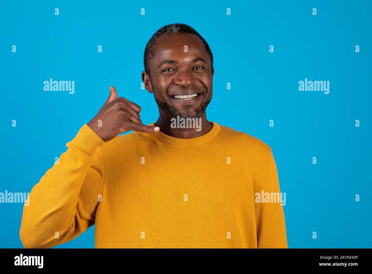 Ein gut aussehender afroamerikaner, der ein "Call me" -Schild zeigt Stockfoto