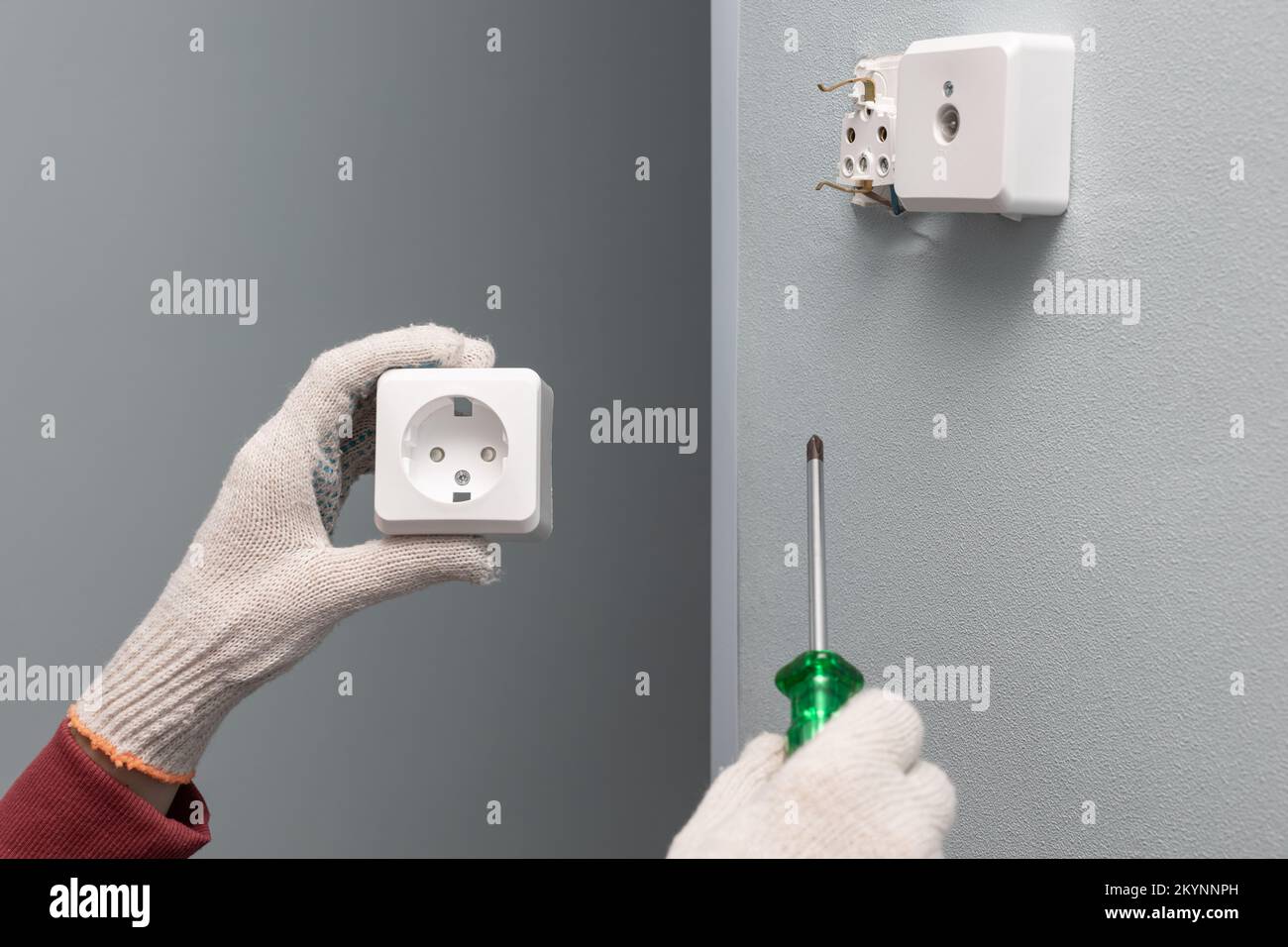 Mann, der eine Steckdose mit einem Schraubenzieher repariert  Stockfotografie - Alamy