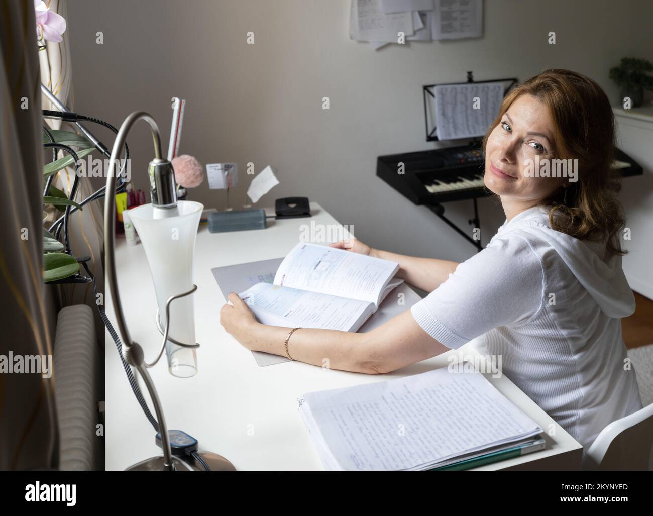 Die Frau schaute von ihrer Lektüre auf und lächelte. Stockfoto