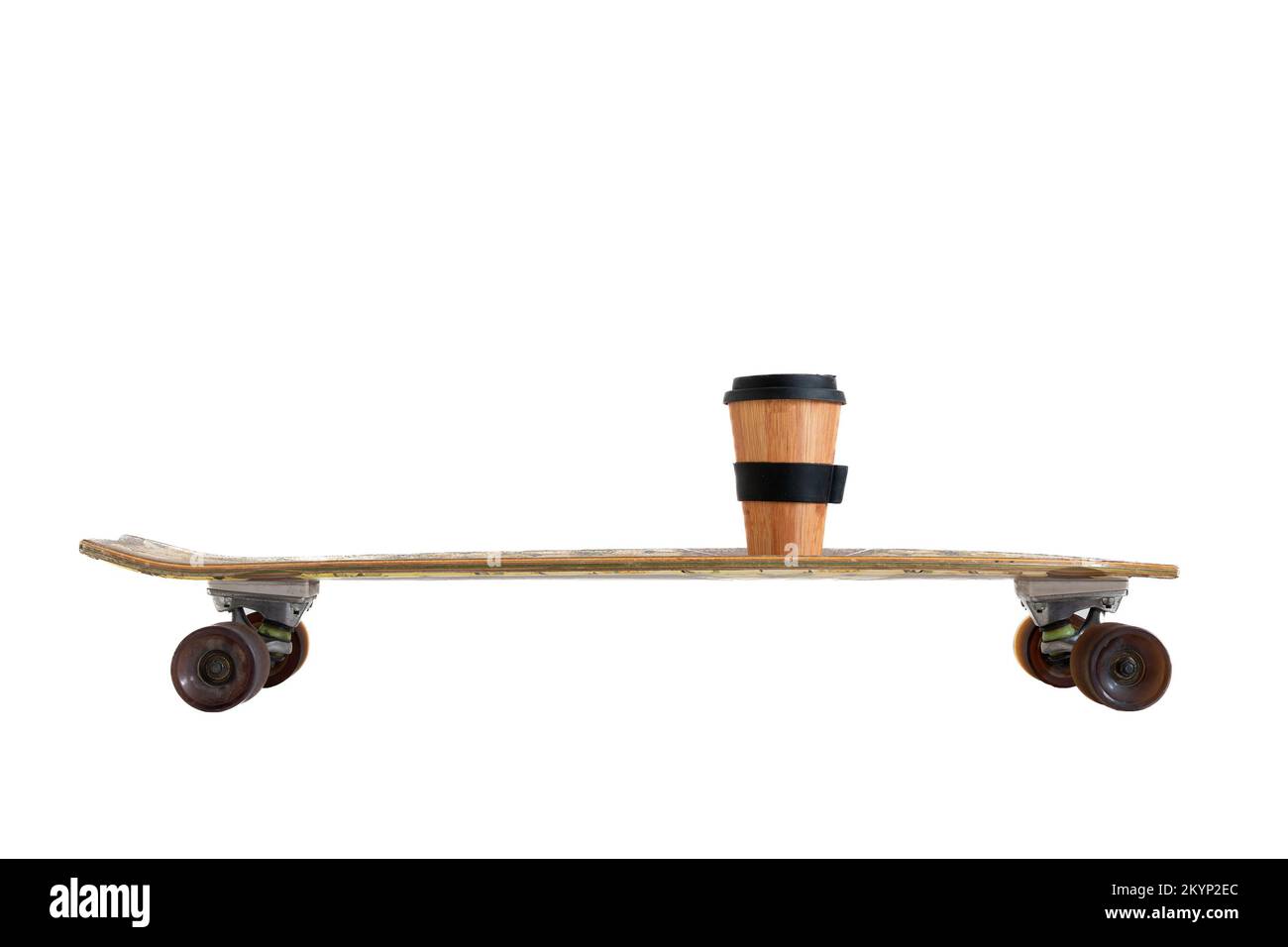 Seitenansicht des alten Longboard-Skateboards mit einer wiederverwendbaren Tasse Kaffee zum Mitnehmen, isoliert auf weißem Hintergrund Stockfoto