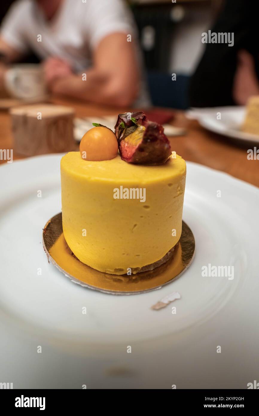 Ein Stück ROHEN, veganen Mango-Mousse-Kuchen auf dem Goldteller. Stockfoto