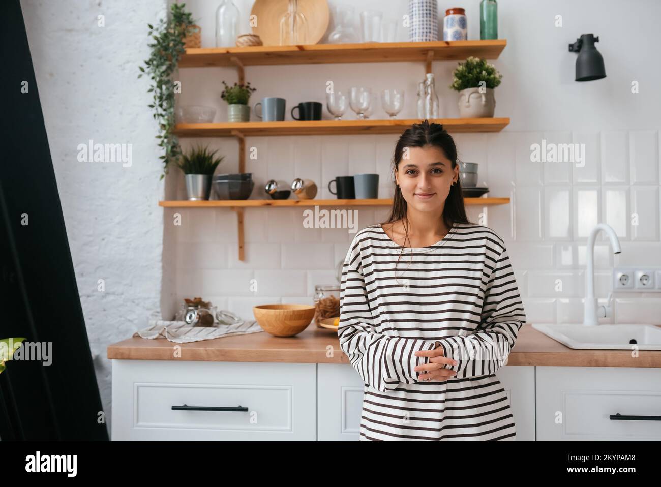 Junge Frau stand in der Nähe der Rezeption in der Küche Stockfoto