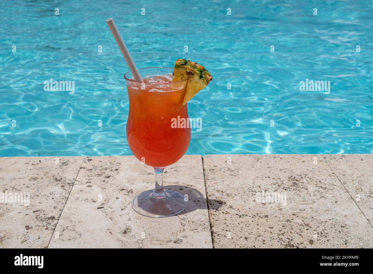 Tropisches Getränk am Rand eines Swimmingpools an einem sonnigen Tag Stockfoto