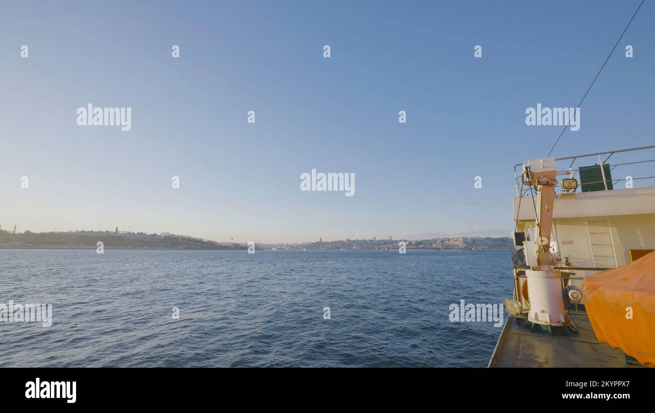 Zeitraffer des Segelns auf dem Boot an sonnigen Tagen. Aktion. Blick von der Seite des Bootes beim schnellen Schwimmen zum Ufer der Küstenstadt. Boot fährt durch den Hafen am Seehafen auf Stockfoto