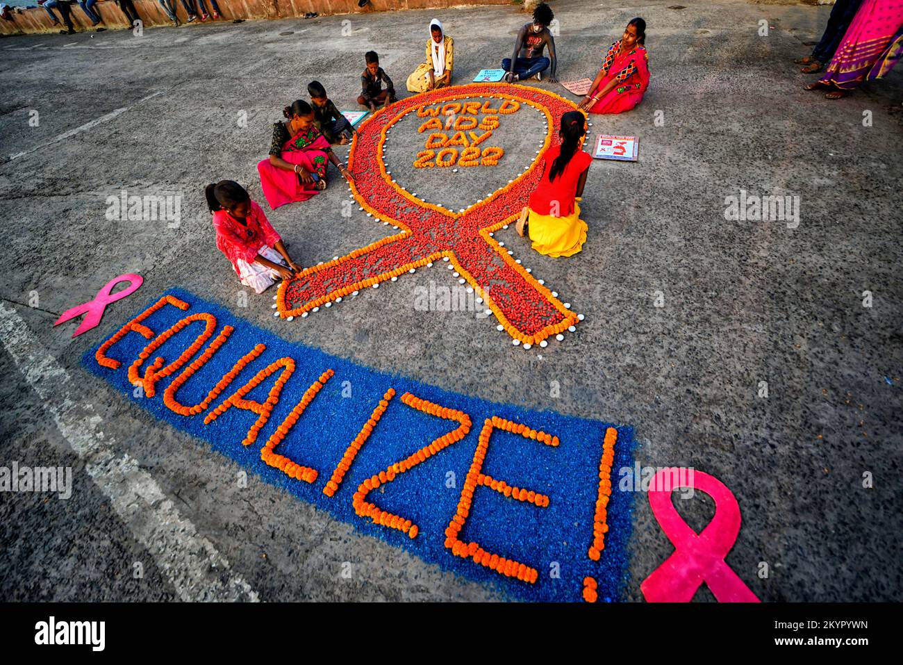 Kalkutta, Indien. 01.. Dezember 2022. Eine Gruppe von Aktivisten sah während der Sensibilisierungskampagne zum Welt-Aids-Tag Kerzen um ein rotes Band anzünden. Der Welt-Aids-Tag findet jedes Jahr am 1.. Dezember statt, um das Bewusstsein und die Unterstützung für HIV/Aids-Kranke zu schärfen. Kredit: SOPA Images Limited/Alamy Live News Stockfoto