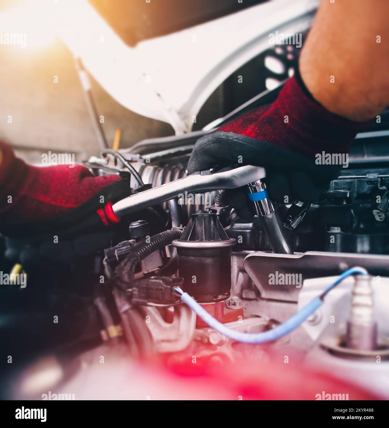 Kfz-Mechaniker repariert Motor mit Steckschlüssel in der Kfz-Reparaturwerkstatt, Kfz-Wartungsservice-Konzept Stockfoto