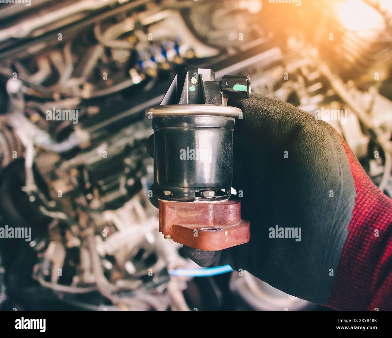 Nahaufnahme der EGR-Abgasrückführung in der Auto-mechanischen Hand, Fahrzeugteilekonzept. Stockfoto