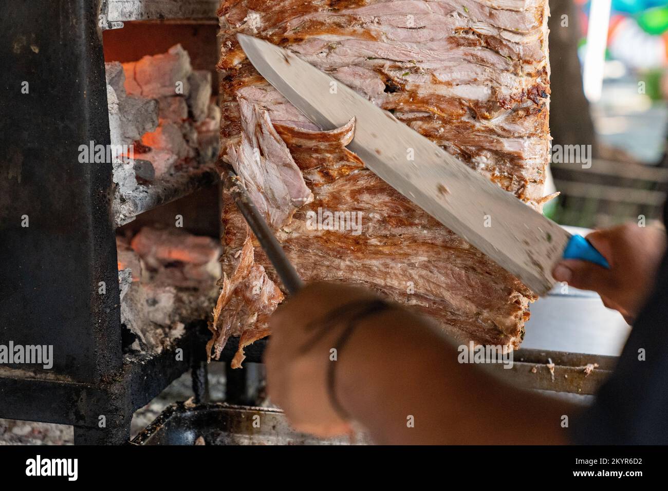 Taquero schneidet gespießtes Schweinefleisch für Tacos al Pastor in Mexico City Stockfoto