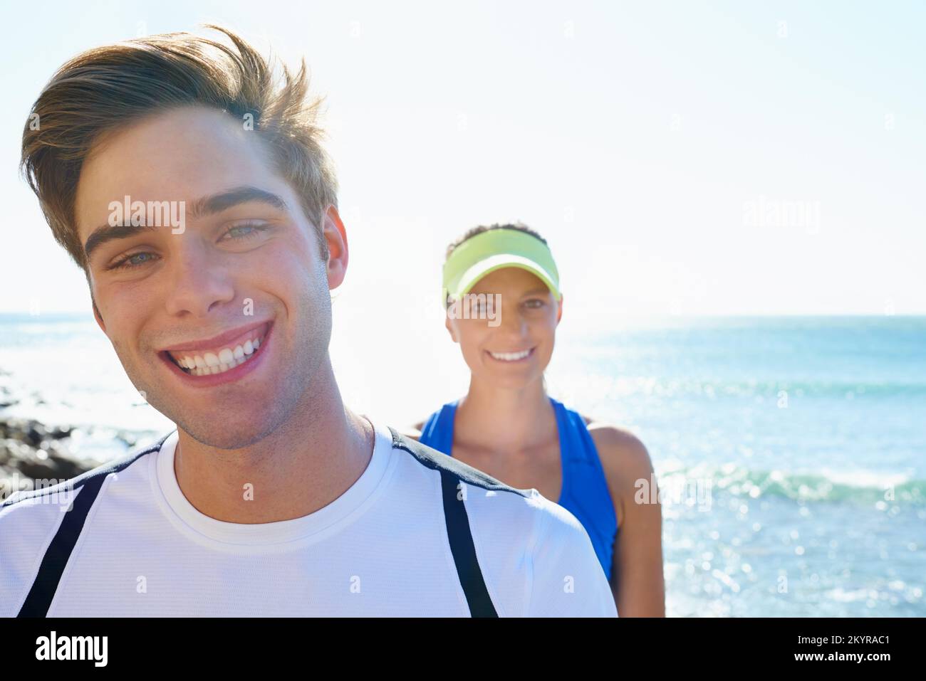 Bewegung bringt sie zum Lächeln. Porträt eines jungen sportlichen Paares, das draußen steht. Stockfoto