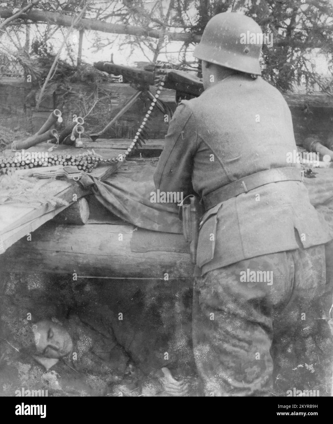Deutscher Soldat aus dem 2. Weltkrieg feuert eine MG42 aus einer versteckten Position auf dem nördlichen Sektor der russischen Front 1944 ab. Der Mann ist ein estnischer Freiwilliger in der Waffen SS Stockfoto