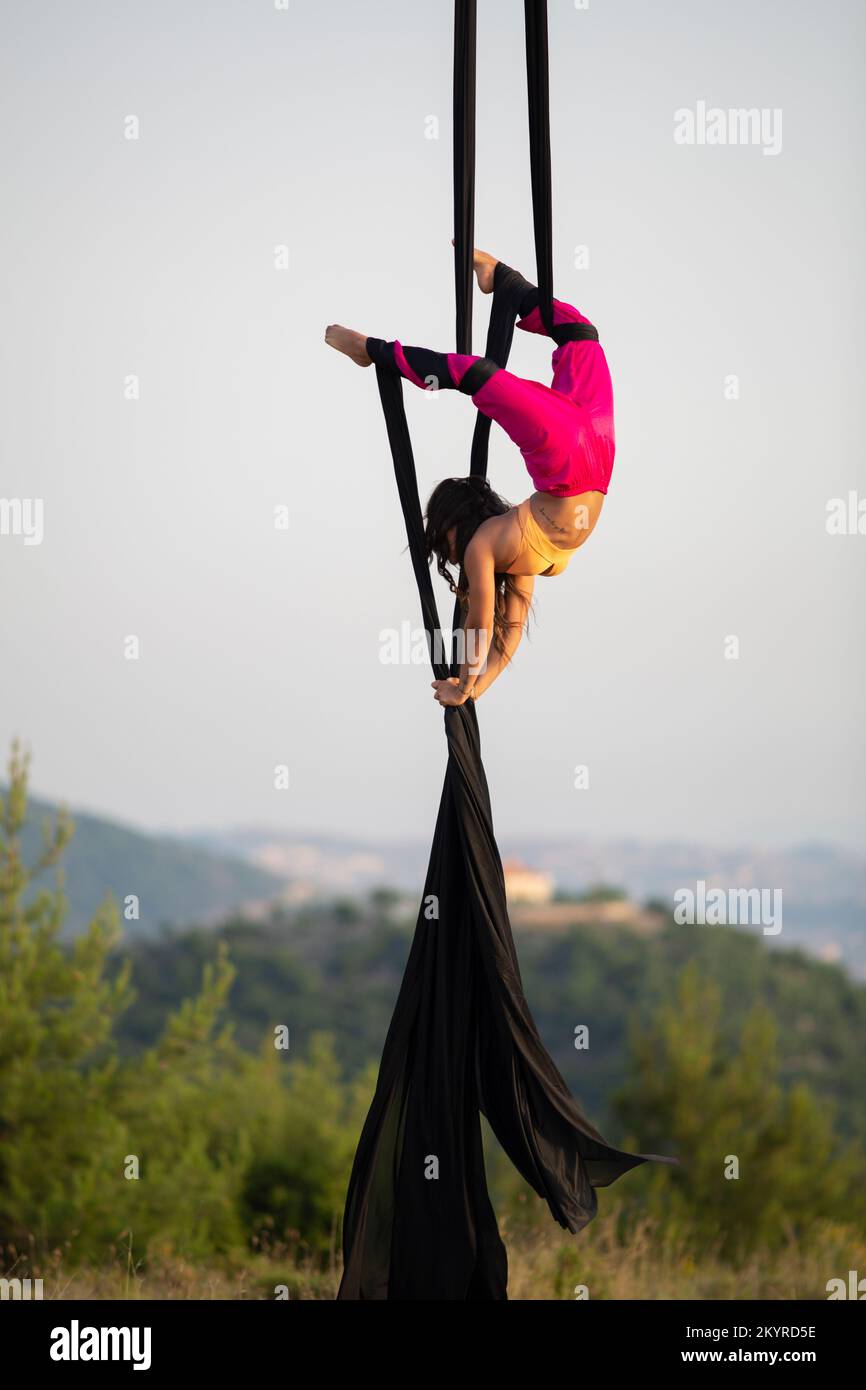 Junge weibliche Luftreinigerin, die im Freien auf Seide auftritt Stockfoto