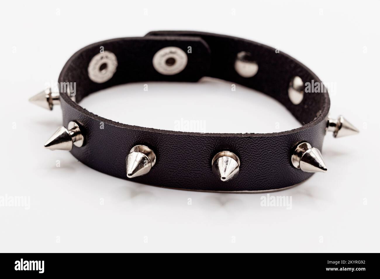 Ein Armband mit Nieten und schwarzem Leder auf weißem Hintergrund Stockfoto