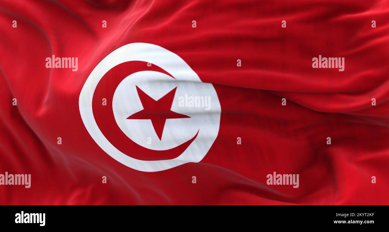 Nahaufnahme der tunesischen Nationalflagge, die im Wind winkt. Die Tunesische Republik ist das nördlichste Land Afrikas. Strukturierter Stoffhintergrund Stockfoto