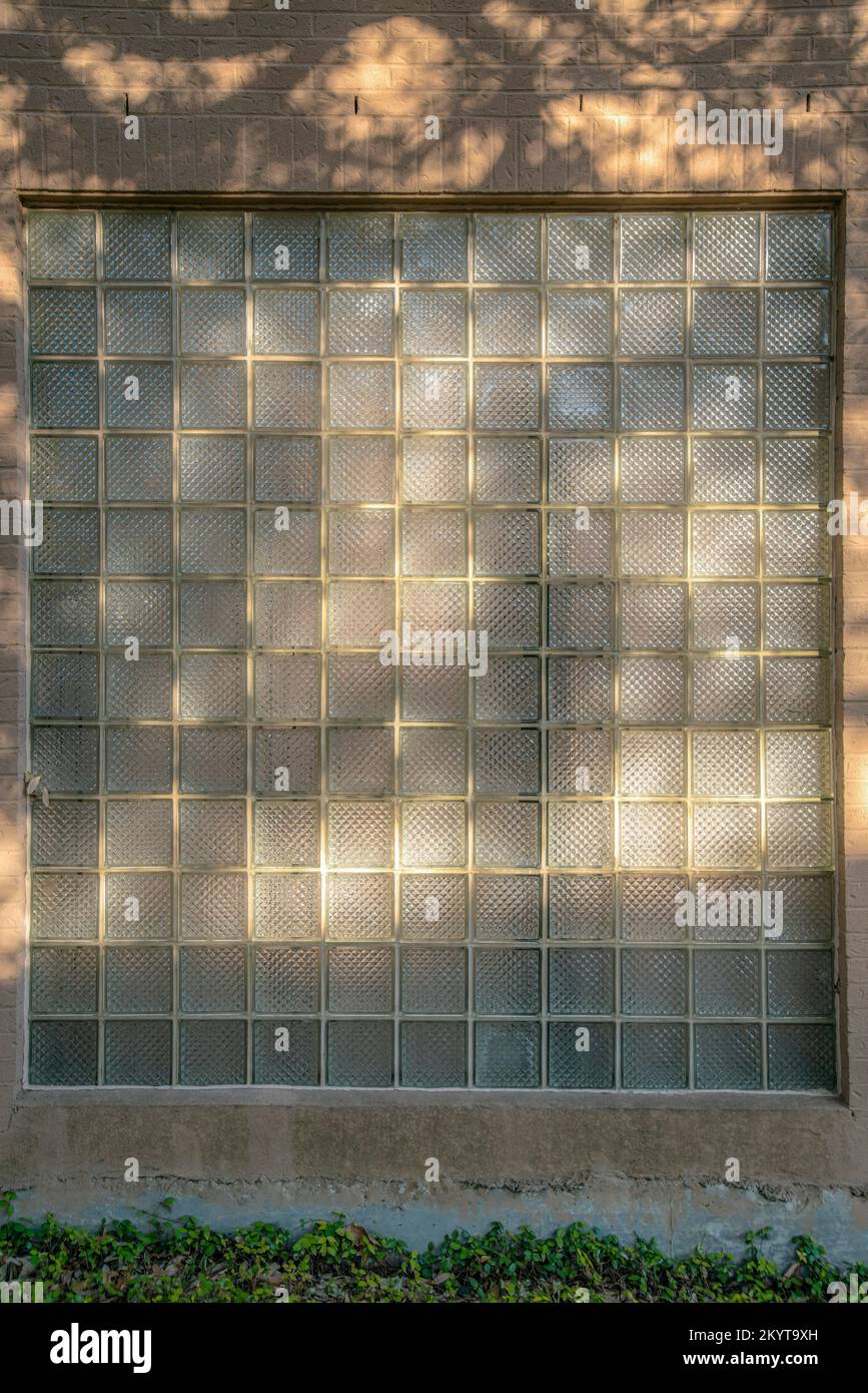 Fenster eines Gebäudes mit dicken Milchglaspaneelen in San Antonio Texas. Außenansicht eines Gebäudes mit Nahaufnahme des sonnigen Fensters auf einem sonnigen d Stockfoto