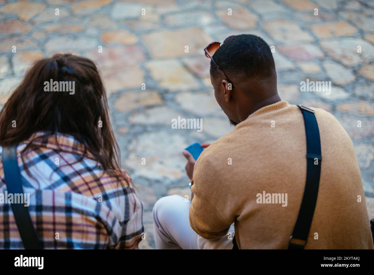 Männliche und weibliche Touristen hingen den ganzen Tag in der Stadt herum. Sie sitzen auf einer Bank und machen eine Pause Stockfoto