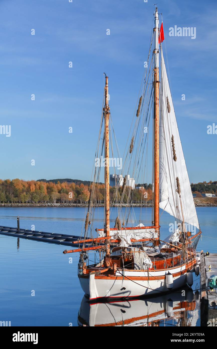 An einem sonnigen Tag liegt eine alte Segelyacht im Hafen von Stenkjer in der Region Trondheim. Vertikales Foto Stockfoto