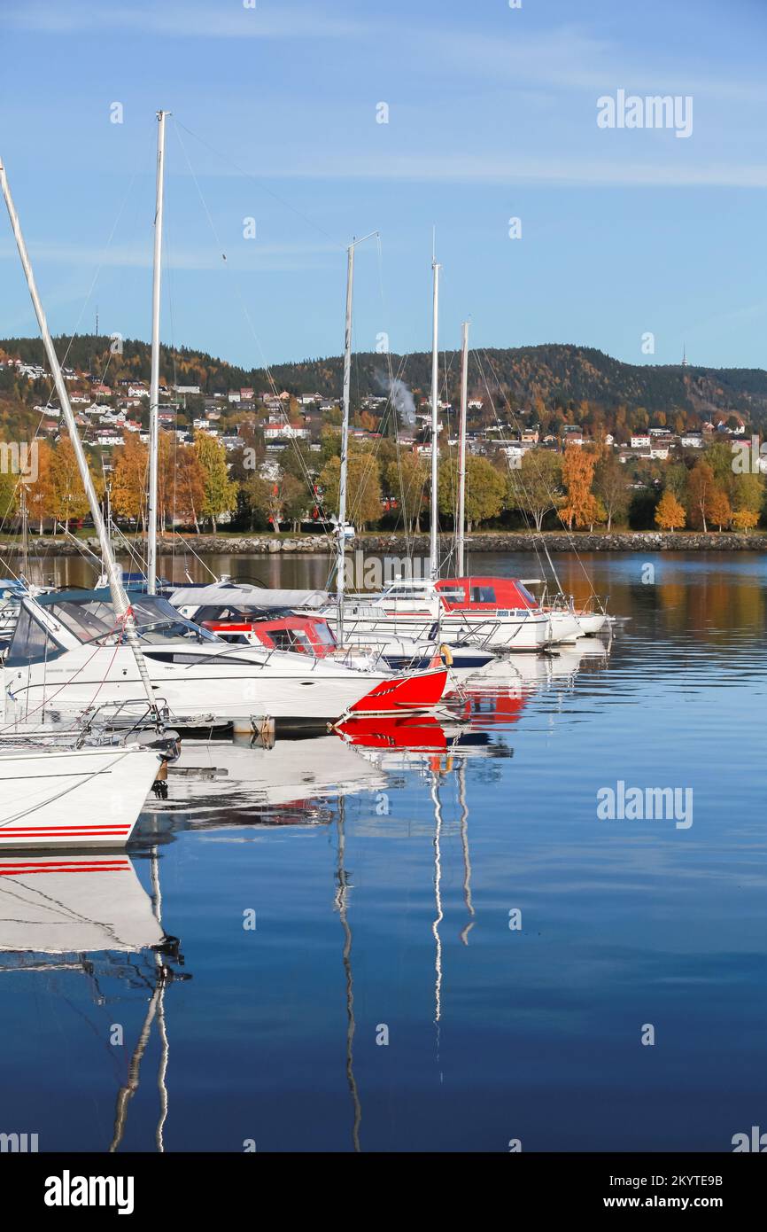 Norwegische Küstenlandschaft mit festgemachten weißen roten Booten. Stenkjer, Region Trondheim. Vertikales Foto Stockfoto