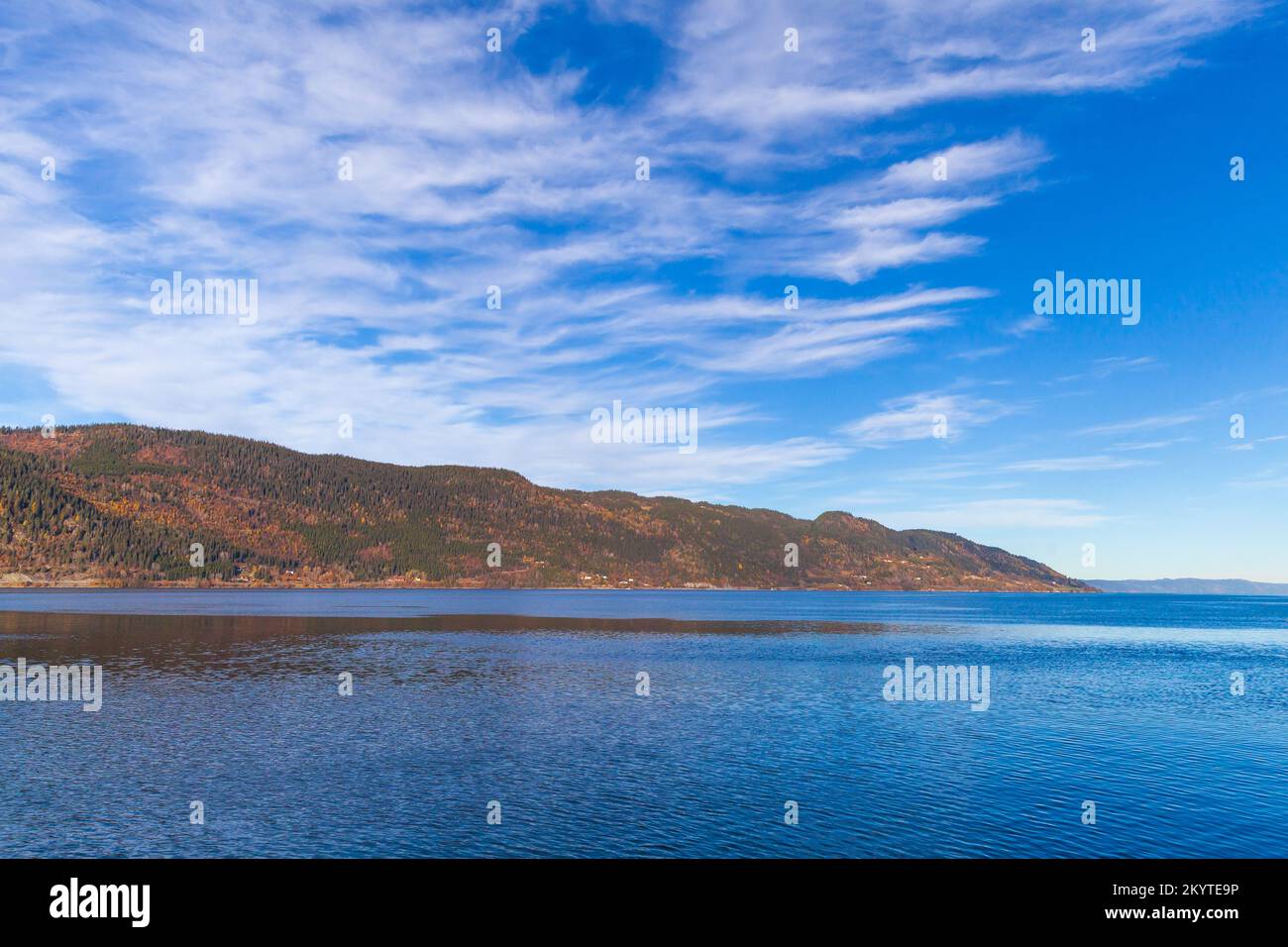 Norwegische Landschaft mit Küstenbergen unter bewölktem Himmel an einem sonnigen Tag Stockfoto