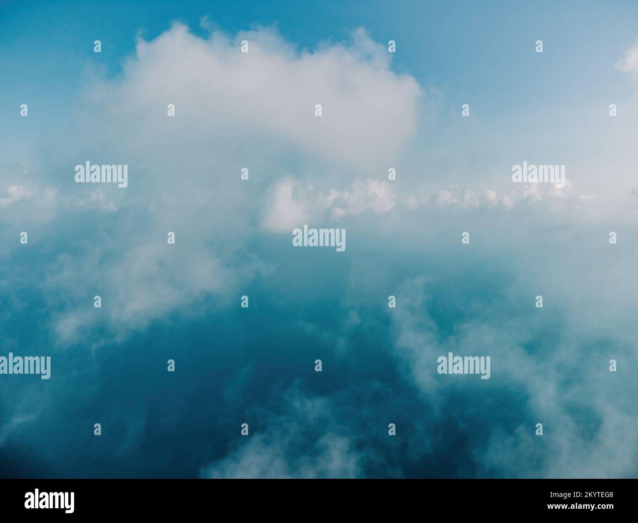 Blauer Himmel mit weißen Wolken über ruhigem Sommerpanorama des Meeres. Draufsicht der Drohne. Abstrakte Luft Natur Sommer Ozean Sonnenuntergang Meer und Himmel Hintergrund Stockfoto