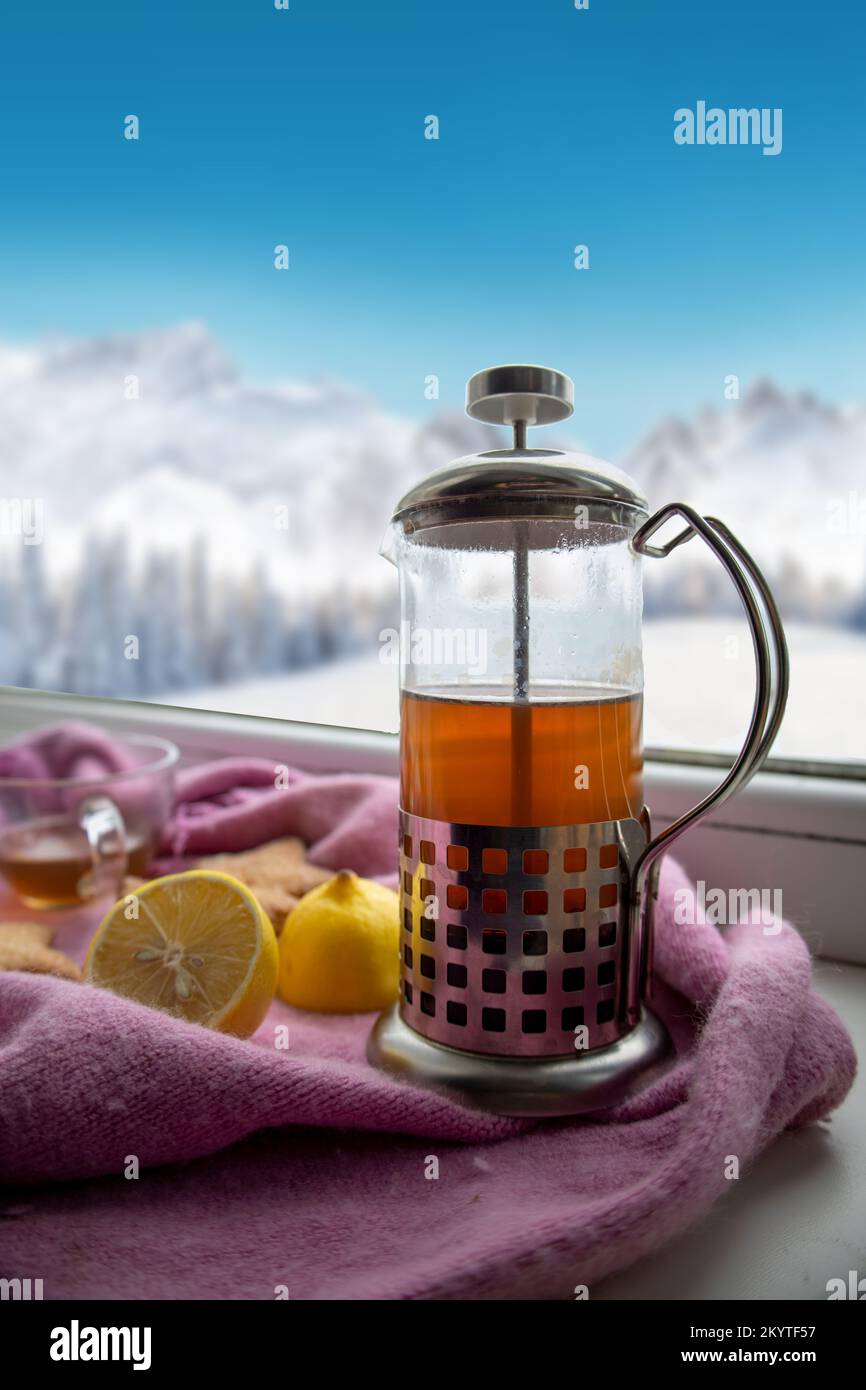 Teekanne mit Tee und Keksen am Winterfenster. Stockfoto