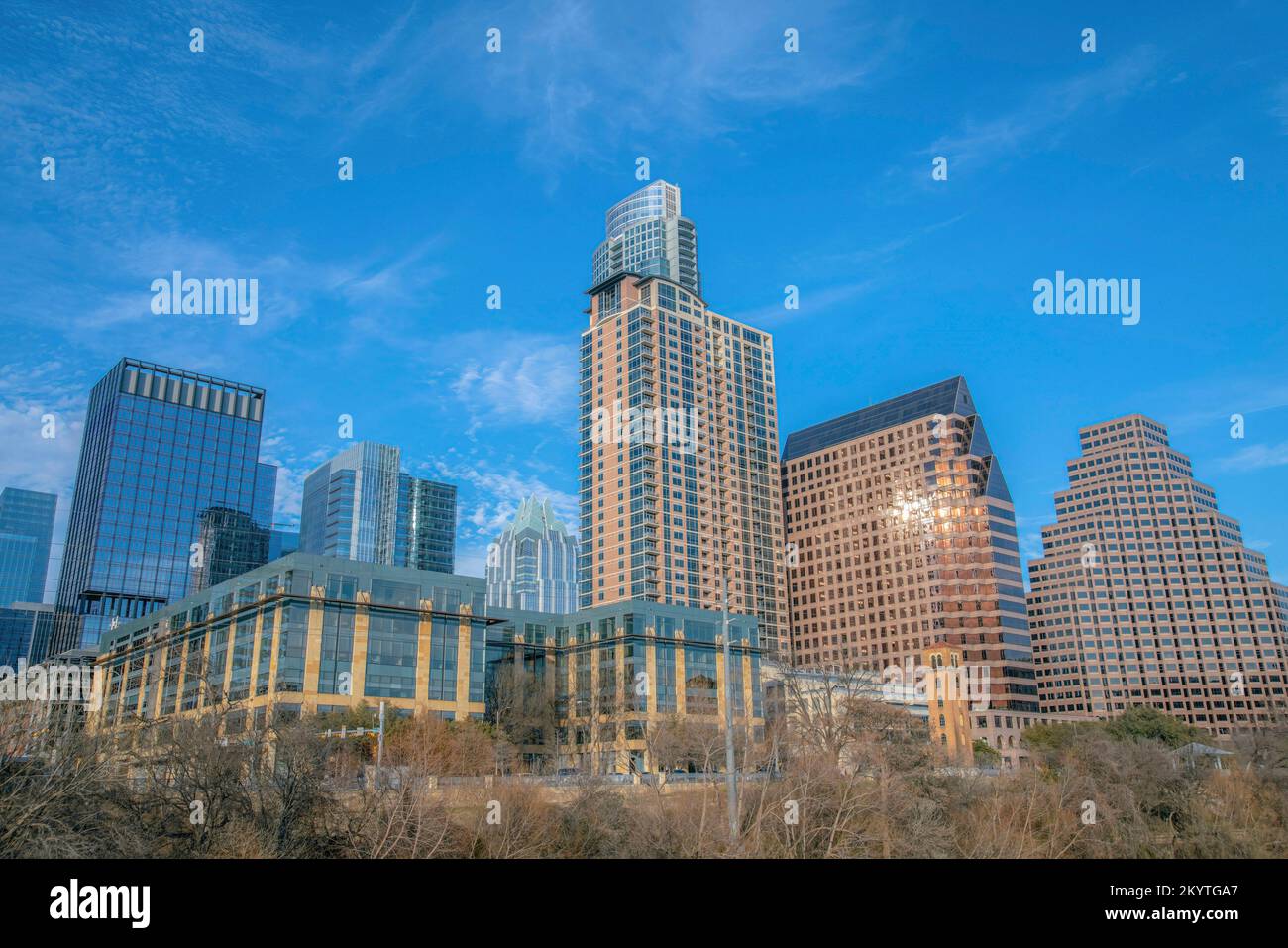 Zeitgenössische Gebäude in Austin, Texas, vor dem Himmel. Hochhäuser mit Wohn- und Firmengebäuden über den blattlosen Bäumen. Stockfoto