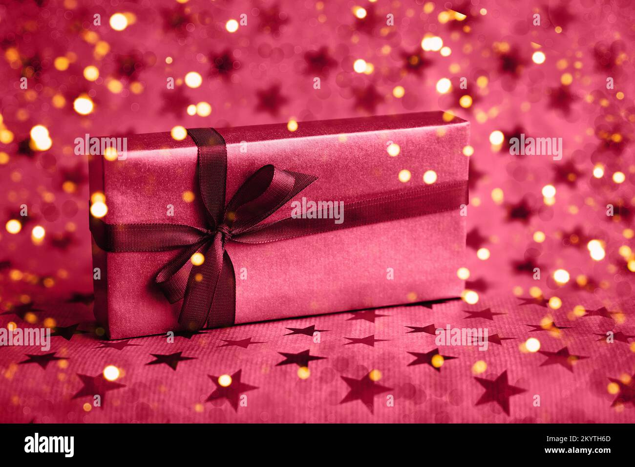 Geschenk- oder Geschenkbox mit roter Schleife auf Sternhintergrund. Farbe des Jahres 2023 mit Farbton. Speicherplatz kopieren. Urlaubskonzept. Stockfoto