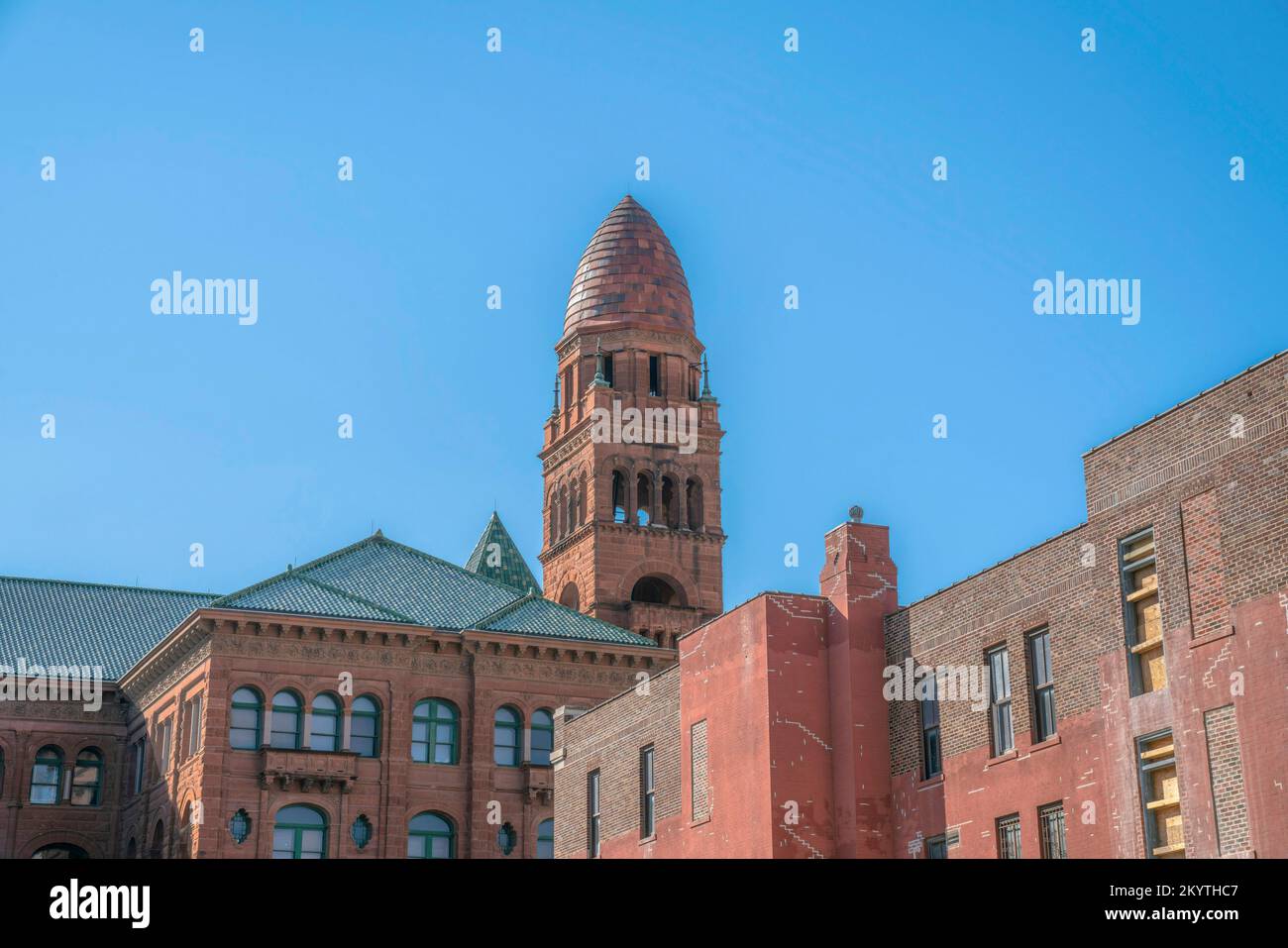Alte Gebäude vor dem klaren blauen Himmel in San Antonio, Texas. Alte Gebäudestrukturen mit roten Ziegeln und kunstvoll verzierten Außenverkleidungen. Stockfoto