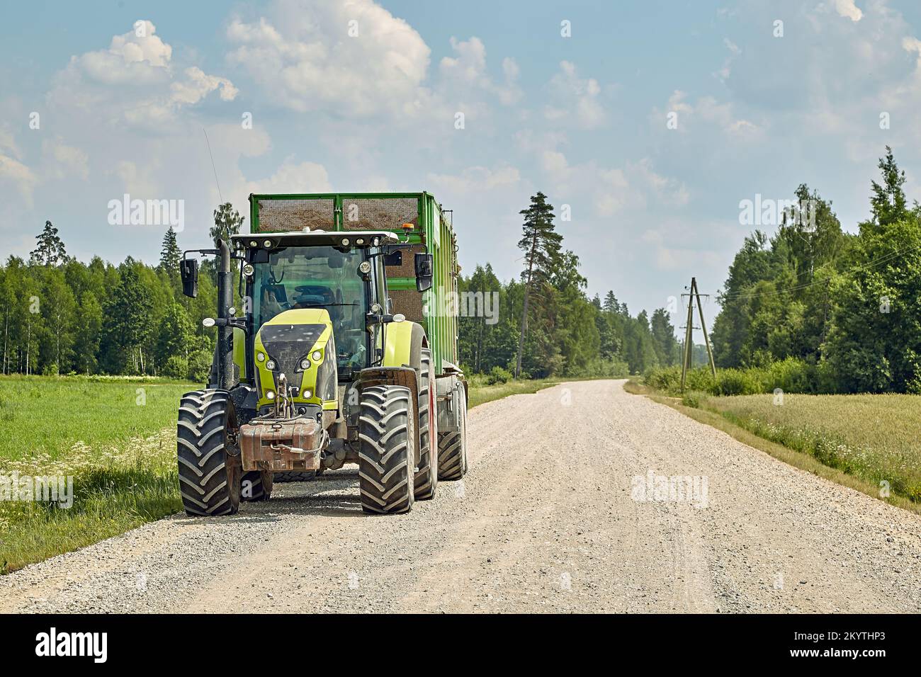 28. Juni 2022, Mengele, Lettland: Traktor transportiert eine Ernte auf schmutzigen Landstraßen zum Hof Stockfoto