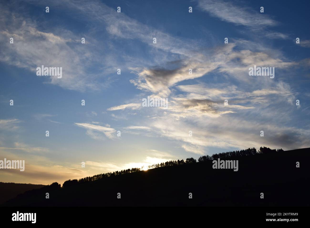 Die weite Aussicht von einem Hügel in Wales zeigt den weiten Himmel und die Wolken und die weit abgelegenen Berge. Stockfoto
