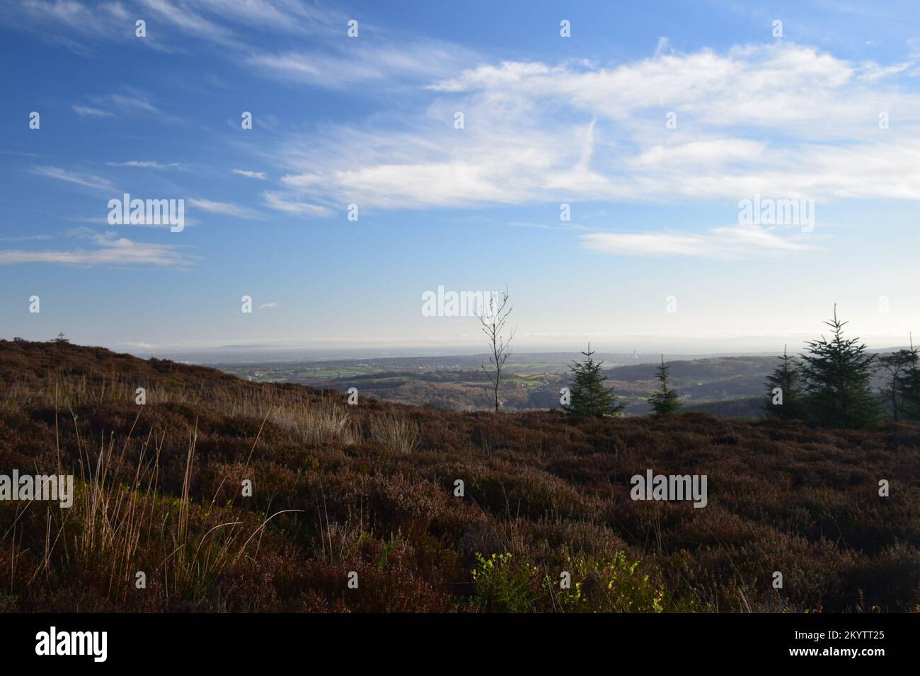 Die weite Aussicht von einem Hügel in Wales zeigt den weiten Himmel und die Wolken und die weit abgelegenen Berge. Stockfoto