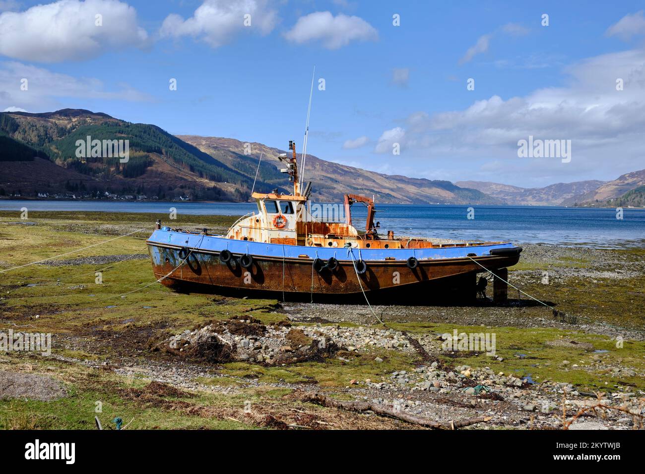 Ein gestrandeter alter Fischtrawler auf Grund am Ufer der nördlichen Minch bei Morvich in den schottischen Highlands, vom Hafen aus gesehen (links) Stockfoto