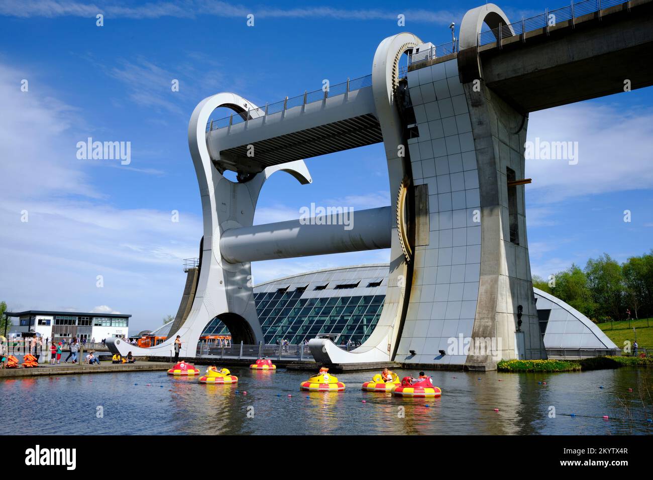 Der Falkirk Wheel Bootslift an einem sonnigen Tag mit Kindern, die in Gummistiefeln im Vordergrund schweben Stockfoto