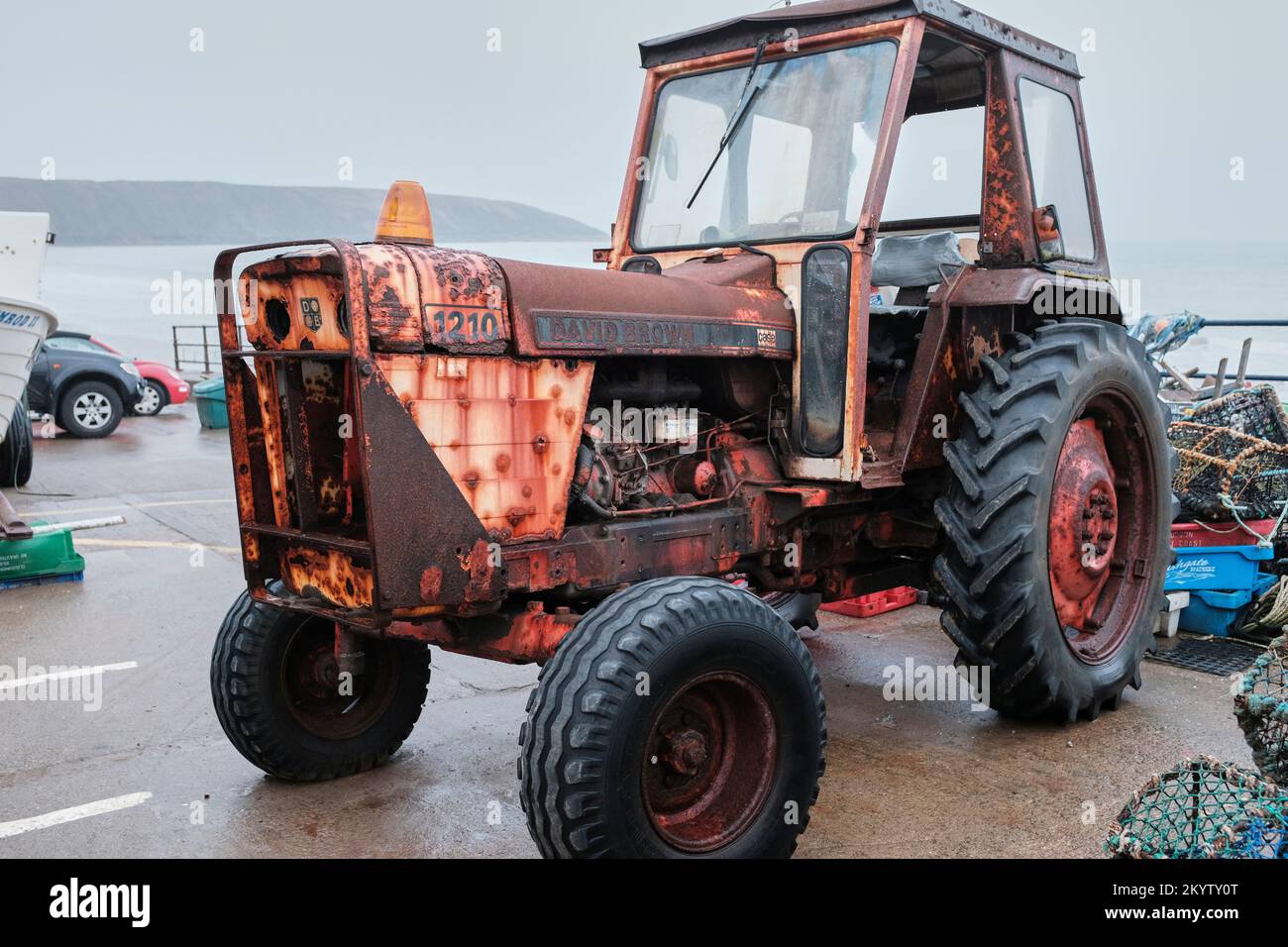 Dreiviertel-Vorderansicht eines rostigen alten David Brown-Traktors, der am Kai auf der linken Seite bei Filey, Yorkshire, geparkt ist Stockfoto