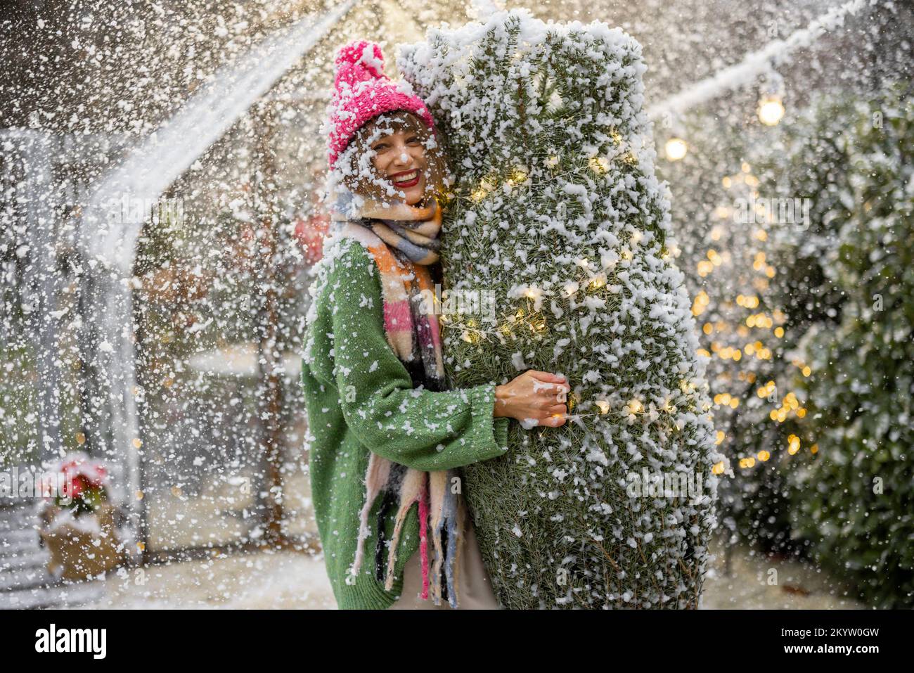 Frau mit Weihnachtsbaum, die sich auf einen Winterurlaub im Freien vorbereitet Stockfoto