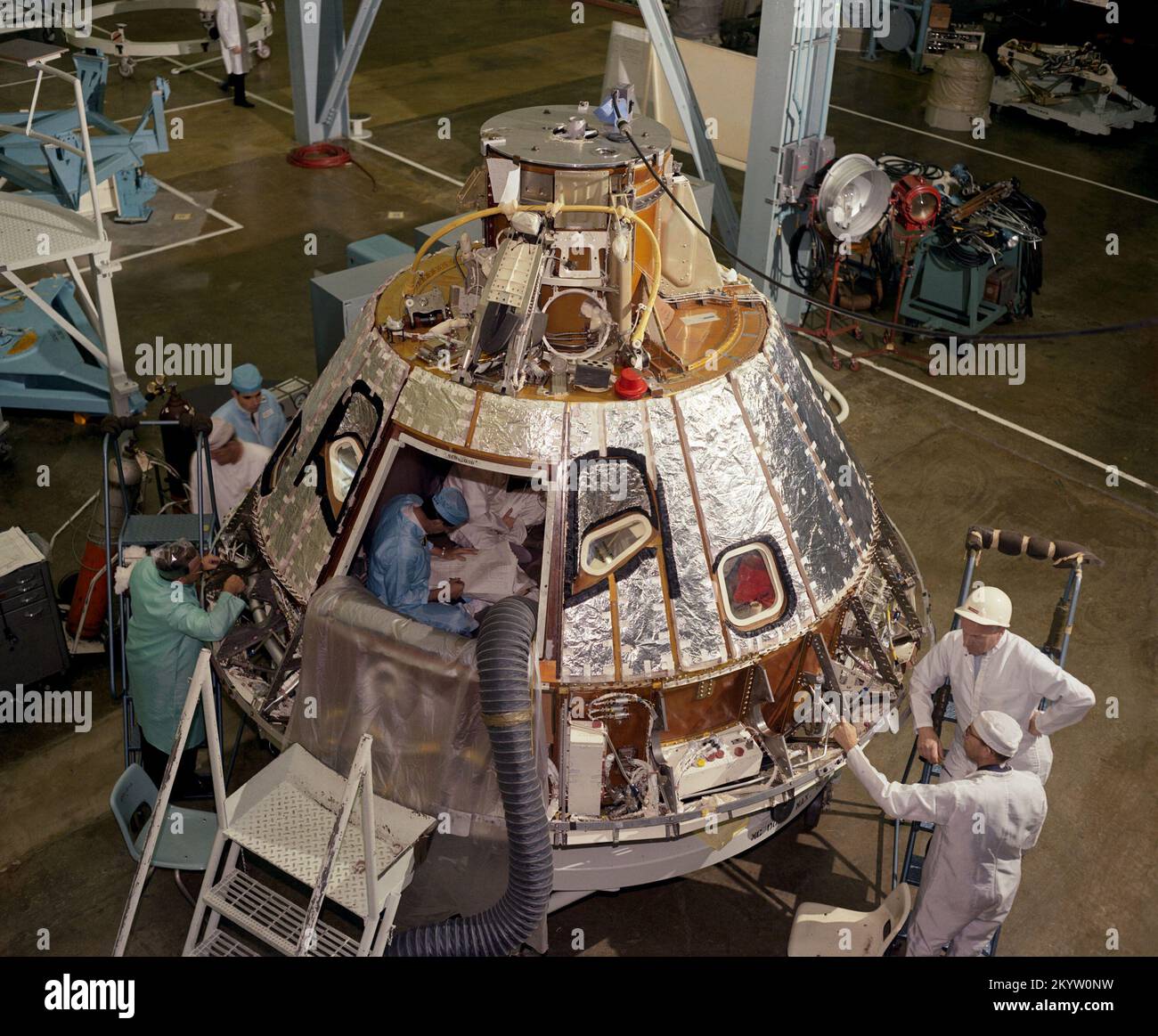 Installation des Hitzeschilds des Steuermoduls Hochwinkelansicht des S/C-012 Command Module, in Richtung -Z-Achse, während der Vorbereitung für die Installation des Hitzeschilds des Bedienfeldfachs, wobei Mechaniker am Achter Bay arbeiten. Bildnummer: S66-41851 Datum: 17. April 1966 Stockfoto