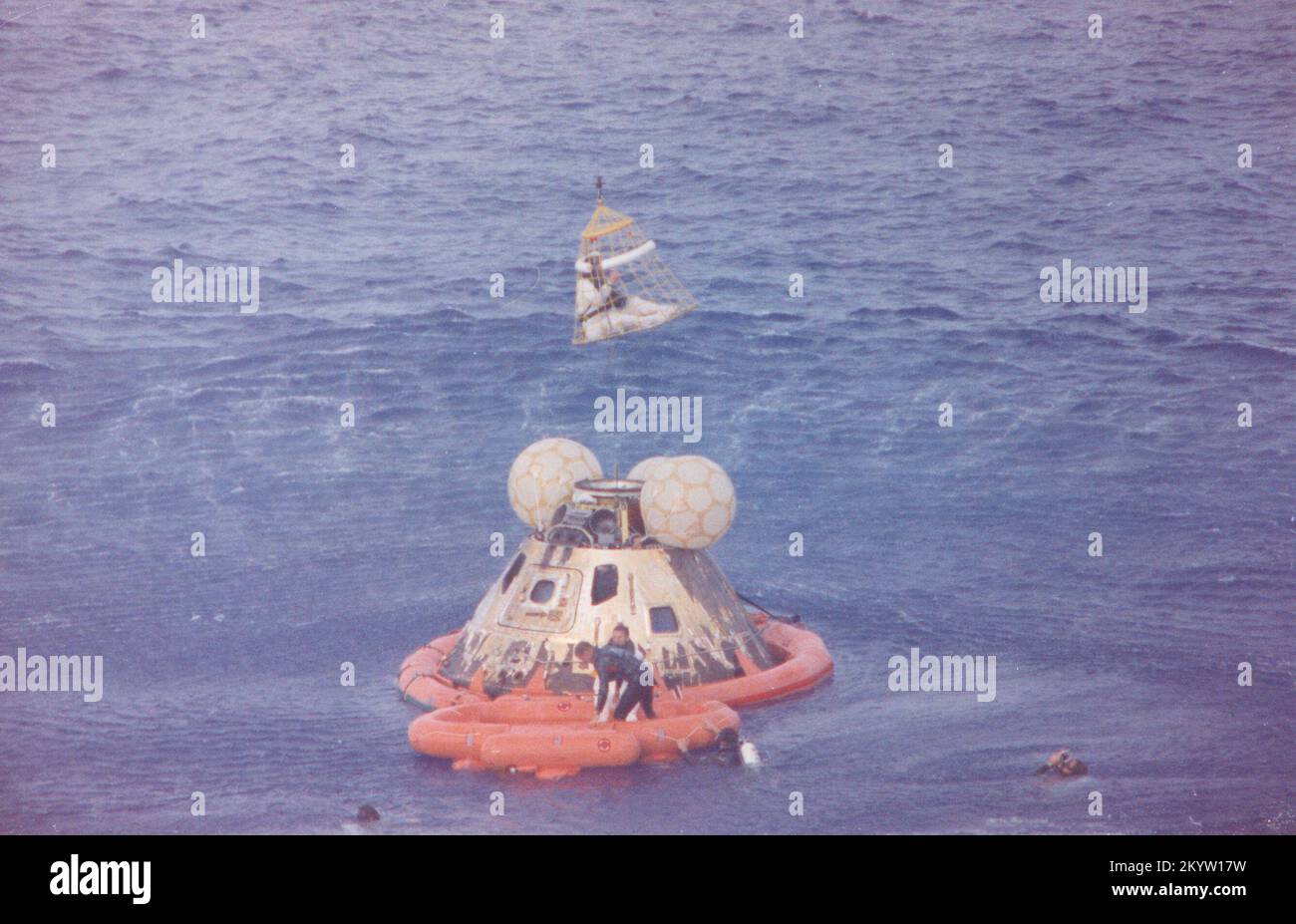 Der Astronaut John L. Swigert Jr., Pilot des Befehlsmoduls, wird an Bord eines Hubschraubers in einem Billy Pugh Helikopter-Rettungsnetz gehoben, während der Astronaut James A. Lovell Jr., Kommandant, an seiner Reihe ist. Astronaut Fred W. Haise, Jr., Pilot des Mondmoduls, ist bereits an Bord des Hubschraubers. Im Leben Floß mit Lovell, und im Wasser sind mehrere Unterwasser-Demolition-Team der US Navy Schwimmer, die bei den Genesungsoperationen assistierten. Die Besatzung wurde in die U.S.S.G. gebracht Iwo Jima, prime Recovery Ship, einige Minuten nachdem die Raumsonde Apollo 13 am 17. April 1970 um 12:01:44 Uhr CST zersplittert war. Stockfoto Der Astronaut John L. Swigert Jr., Pilot des Befehlsmoduls, wird an Bord eines Hubschraubers in einem Billy Pugh Helikopter-Rettungsnetz gehoben, während der Astronaut James A. Lovell Jr., Kommandant, an seiner Reihe ist. Astronaut Fred W. Haise, Jr., Pilot des Mondmoduls, ist bereits an Bord des Hubschraubers. Im Leben Floß mit Lovell, und im Wasser sind mehrere Unterwasser-Demolition-Team der US Navy Schwimmer, die bei den Genesungsoperationen assistierten. Die Besatzung wurde in die U.S.S.G. gebracht Iwo Jima, prime Recovery Ship, einige Minuten nachdem die Raumsonde Apollo 13 am 17. April 1970 um 12:01:44 Uhr CST zersplittert war. Stockfoto