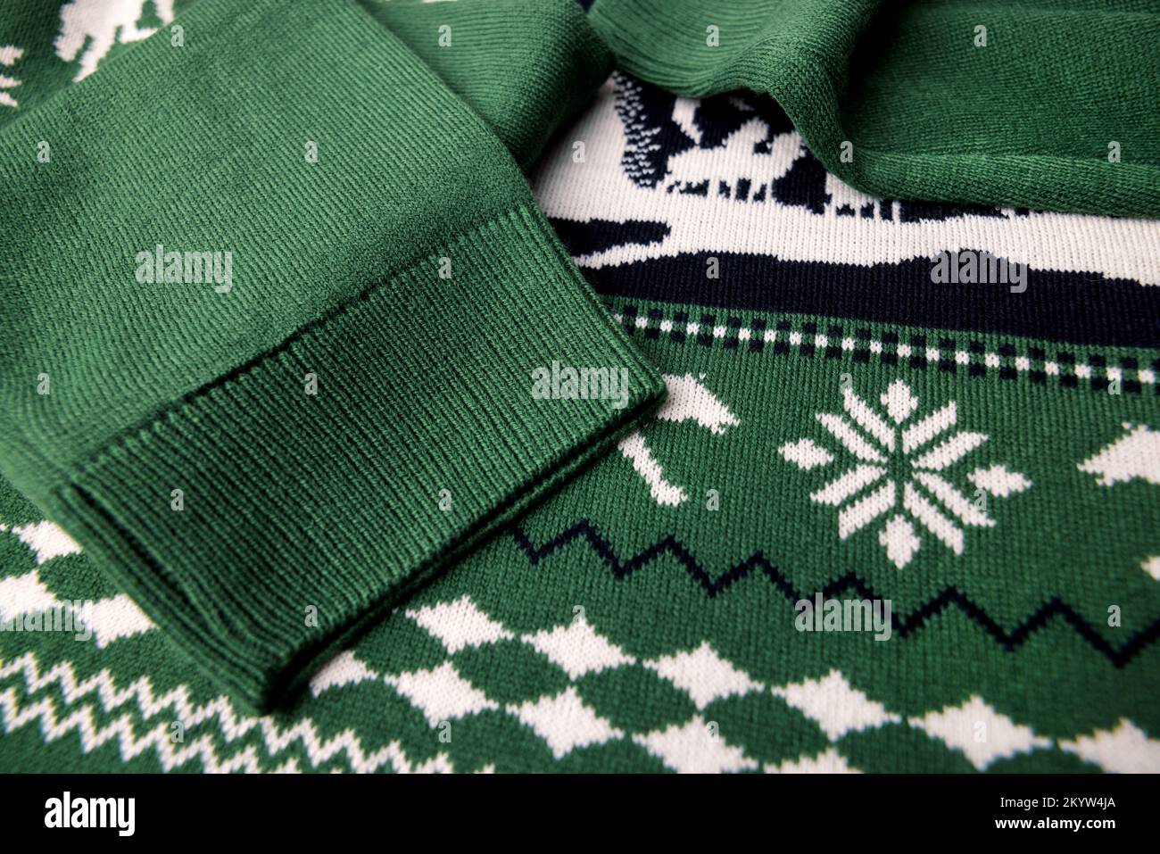 Nahaufnahme der Texturstruktur des grünen weihnachts-Sweaters. Warme Winterkleidung Stockfoto
