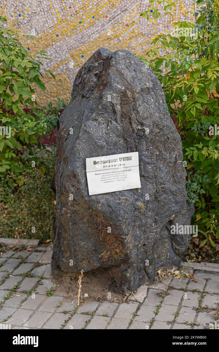 Das Beispiel Kentobe Eisenerz. Ein Stück Eisenerz mit einer Gedenktafel zum Gedenken an die erste Eisenerzmine in Kasachstan, die 1949 von kasachischen Geologen eröffnet wurde. Stockfoto