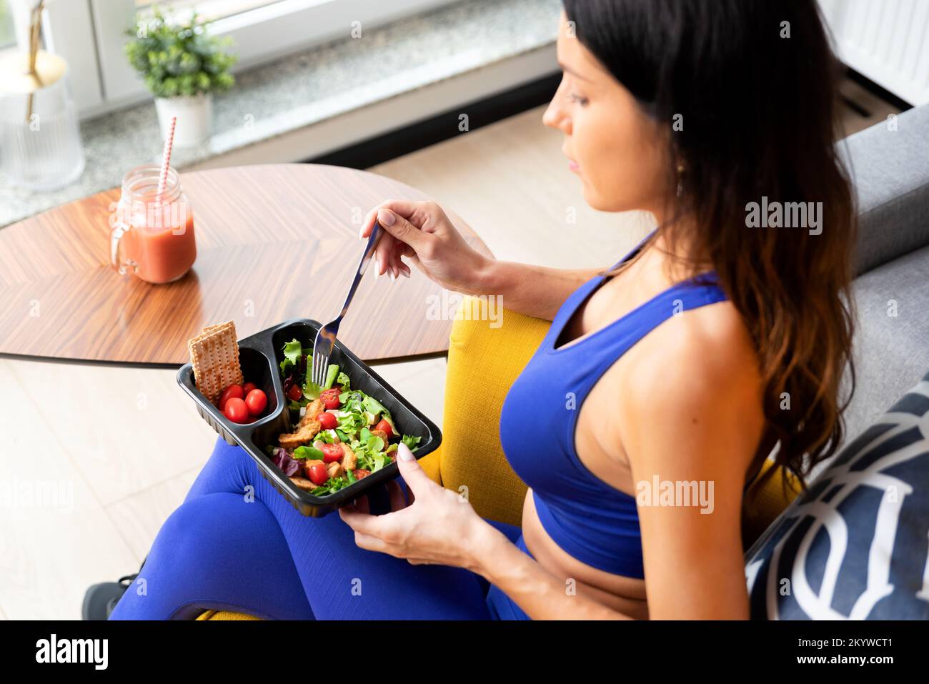 Fit Frau essen gesunde Lebensmittel zu Hause. Gesundes Lifestyle-Konzept mit Fitness-Catering Stockfoto