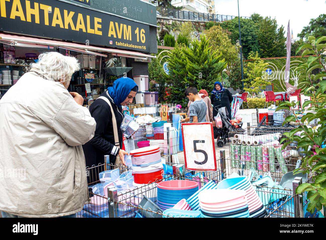 Frauen, die billige Plastikeimer, Küchengeschirr, mit einem Preisschild von % türkischen Lira auf dem Straßenbasar in Bursa, Türkei, einkaufen Stockfoto