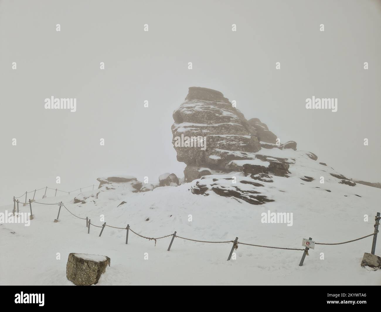 Die Sphinx (Sfinxul), eine natürliche Felsformation im Naturpark Bucegi im Bucegi-Gebirge Rumäniens, an einem verschneiten Wintertag. Stockfoto