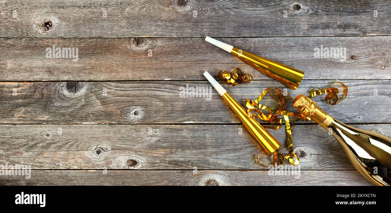Hintergrund der Silvesterfeier mit goldener Champagnerflasche, Geräuschmachern und Partysendern. Perfekt für andere Veranstaltungen wie Weihnachten, Geburtstag oder eine Stockfoto