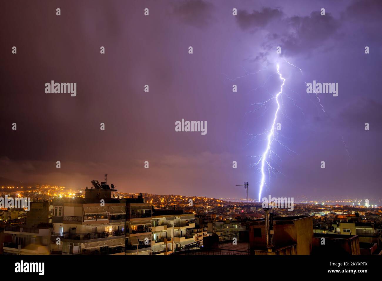 Stadtblick bei Nacht unter Gewitter mit Blitzschlag. Starker Blitz während eines Gewitters in der Stadt. Wolke an Erde, elektrischer Blitz Stockfoto