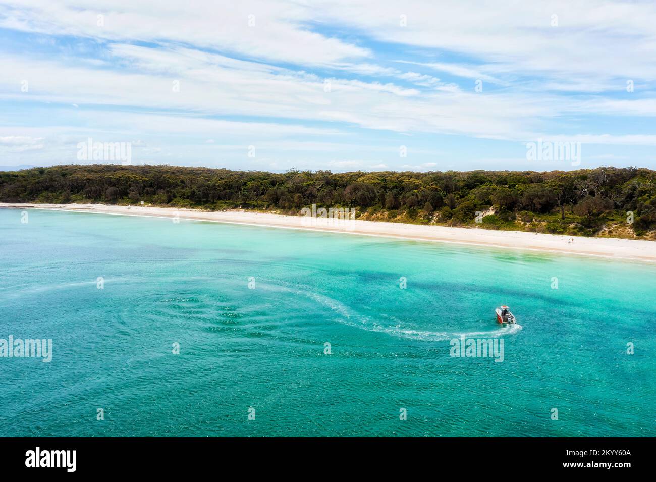 Kleines Motorboot Angeln am langen Strand von Jervis Bay an der Pazifikküste Australiens mit weißem Sand und smaragdgrünem Wasser. Stockfoto