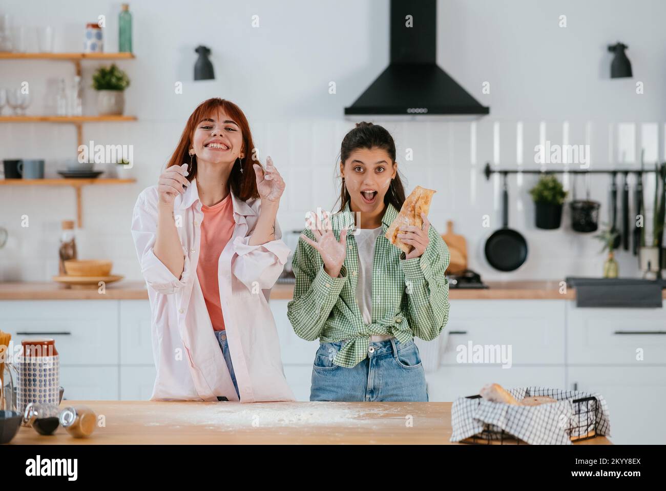 Zwei schöne Frauen spielen mit Mehl in der Küche Stockfoto