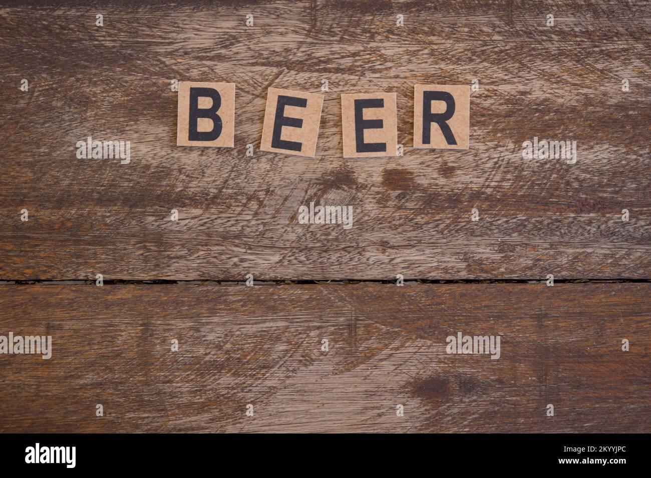 Schild mit kleinen hölzernen Buchstaben mit dem Wort Bier auf rustikalem Holzhintergrund. Stockfoto