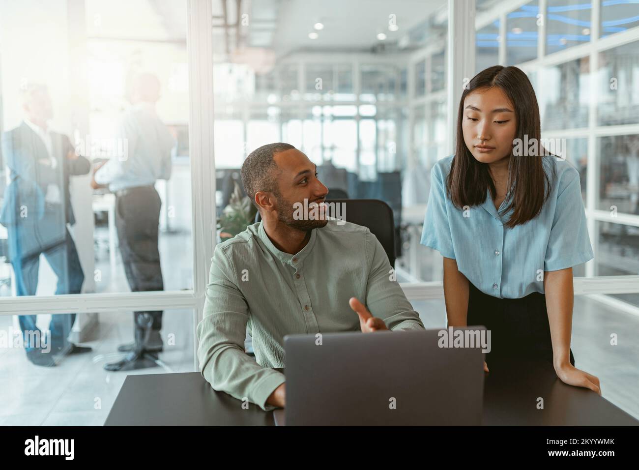 Zwei multiethnische Kollegen aus der Wirtschaft arbeiten in einem modernen Büro zusammen Stockfoto