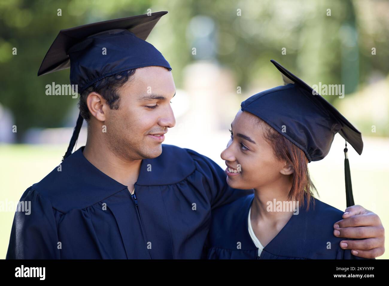 Wir haben zusammen den Abschluss gemacht. Ein glückliches Paar, das zusammen seinen Abschluss macht. Stockfoto