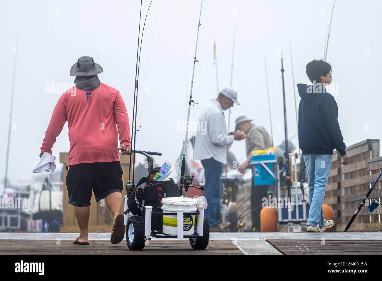 Fischer aus Florida, kurz nach dem „Aufstehen“ an einem sehr nebligen Morgen am Jacksonville Beach Fishing Pier in Jacksonville Beach, Florida. (USA) Stockfoto