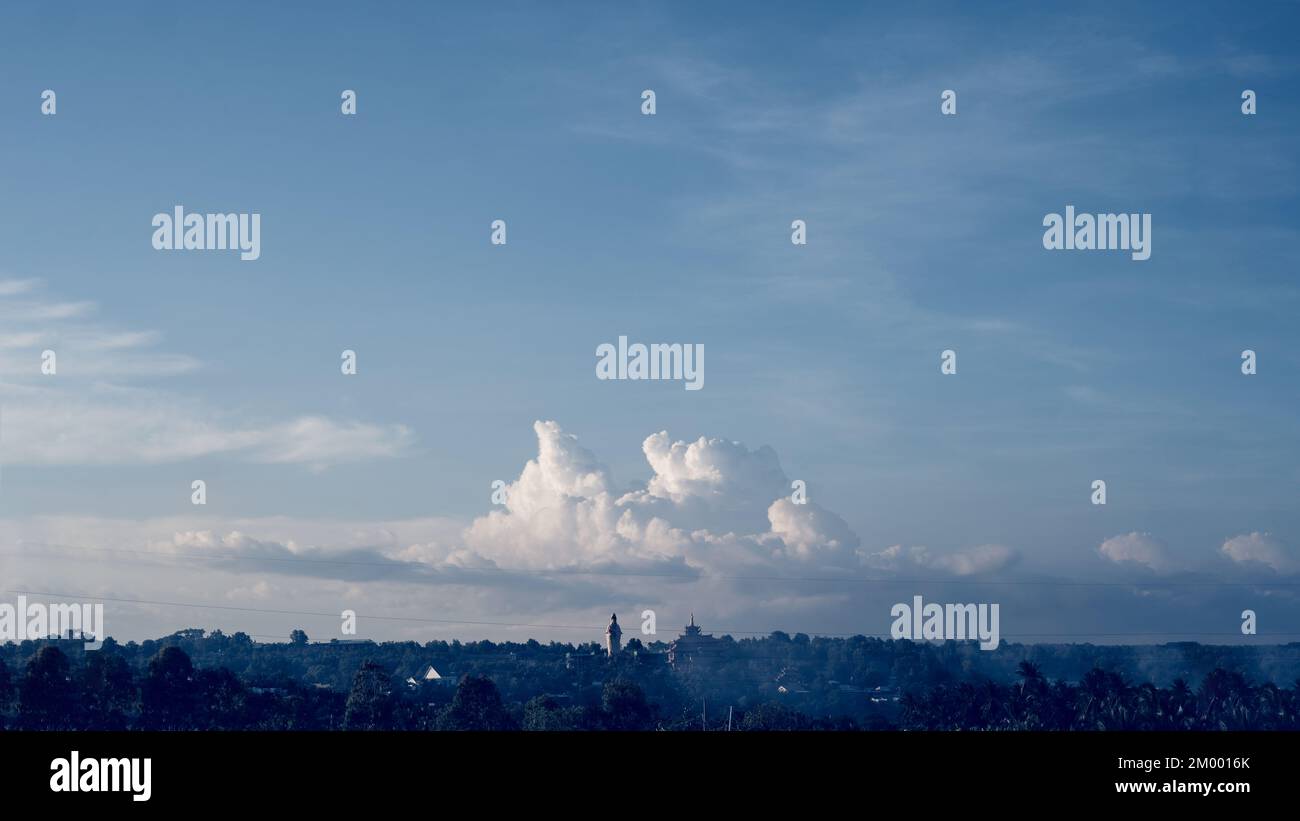 Atmosphere Panorama Cumulus weiße Wolken über buddhistischer Tempelstatue. Dramatischer Himmel Sonnenuntergang Meditation Hintergrund Stockfoto